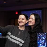 Two grads smile and take a selfie